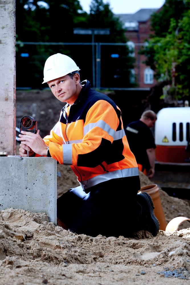 Bygningsarbejder der arbejder ved fundamentsokkel